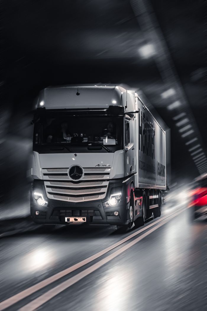 Mercedes-Benz Actros truck speeding through a city tunnel, capturing urban motion and energy.