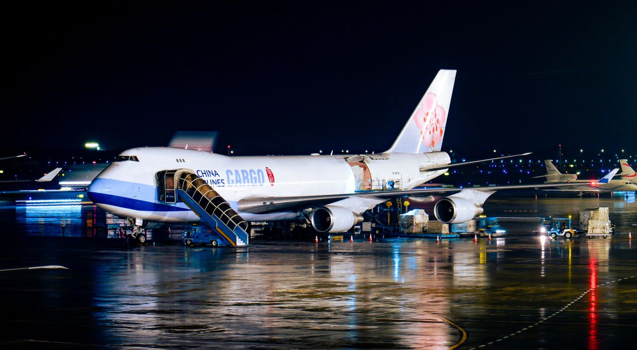 A China Airlines cargo plane being loaded at night with visible airport operations.